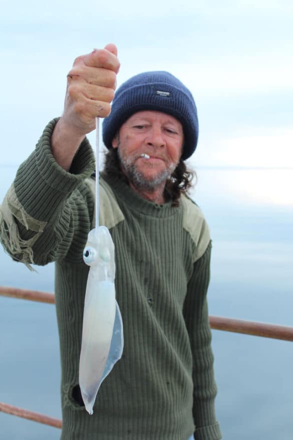 A man holding his calamari catch.